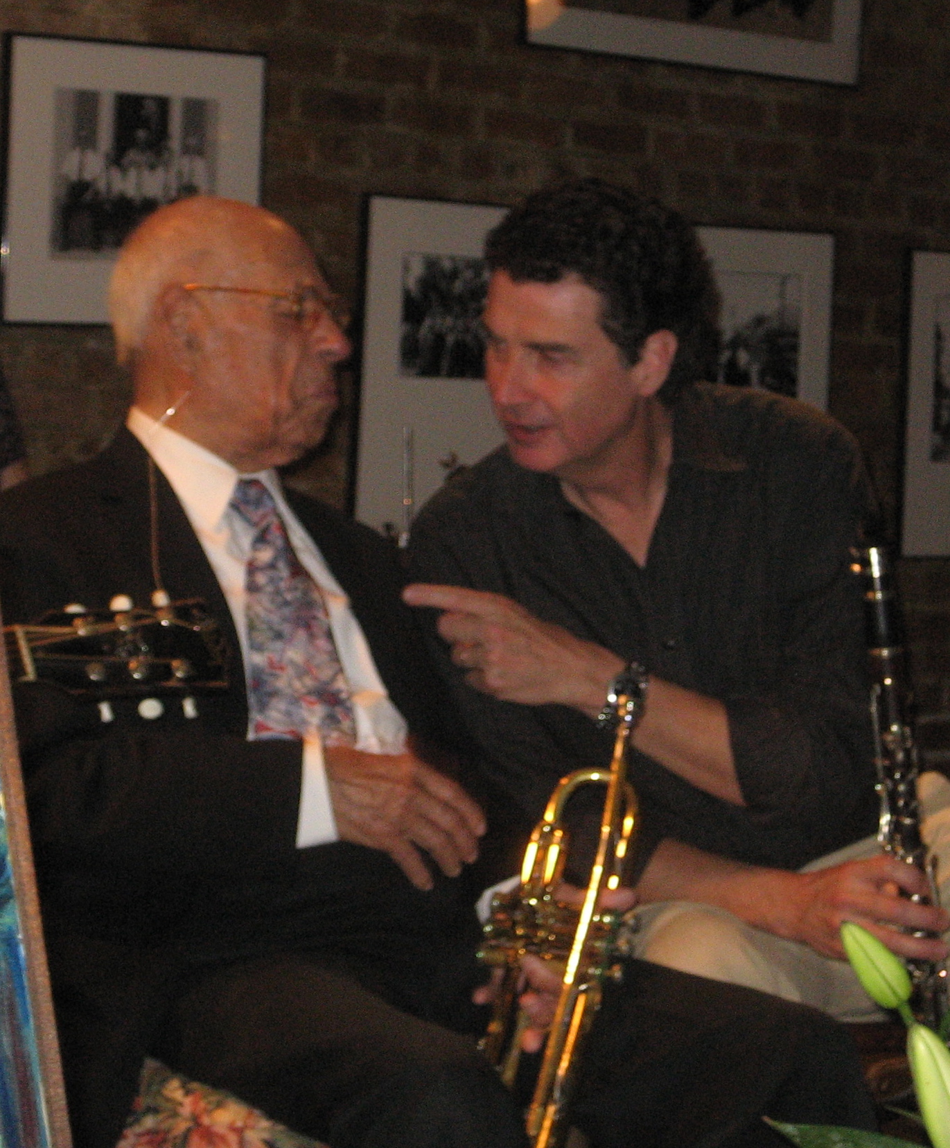 two older gentlemen sharing a conversation as they play instruments