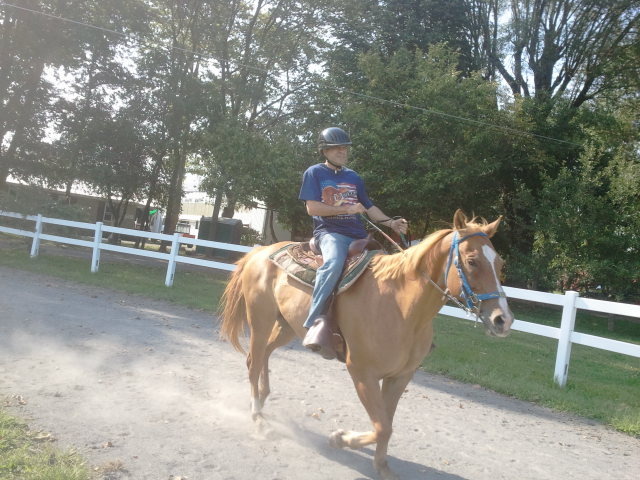 the woman is riding the horse down the road