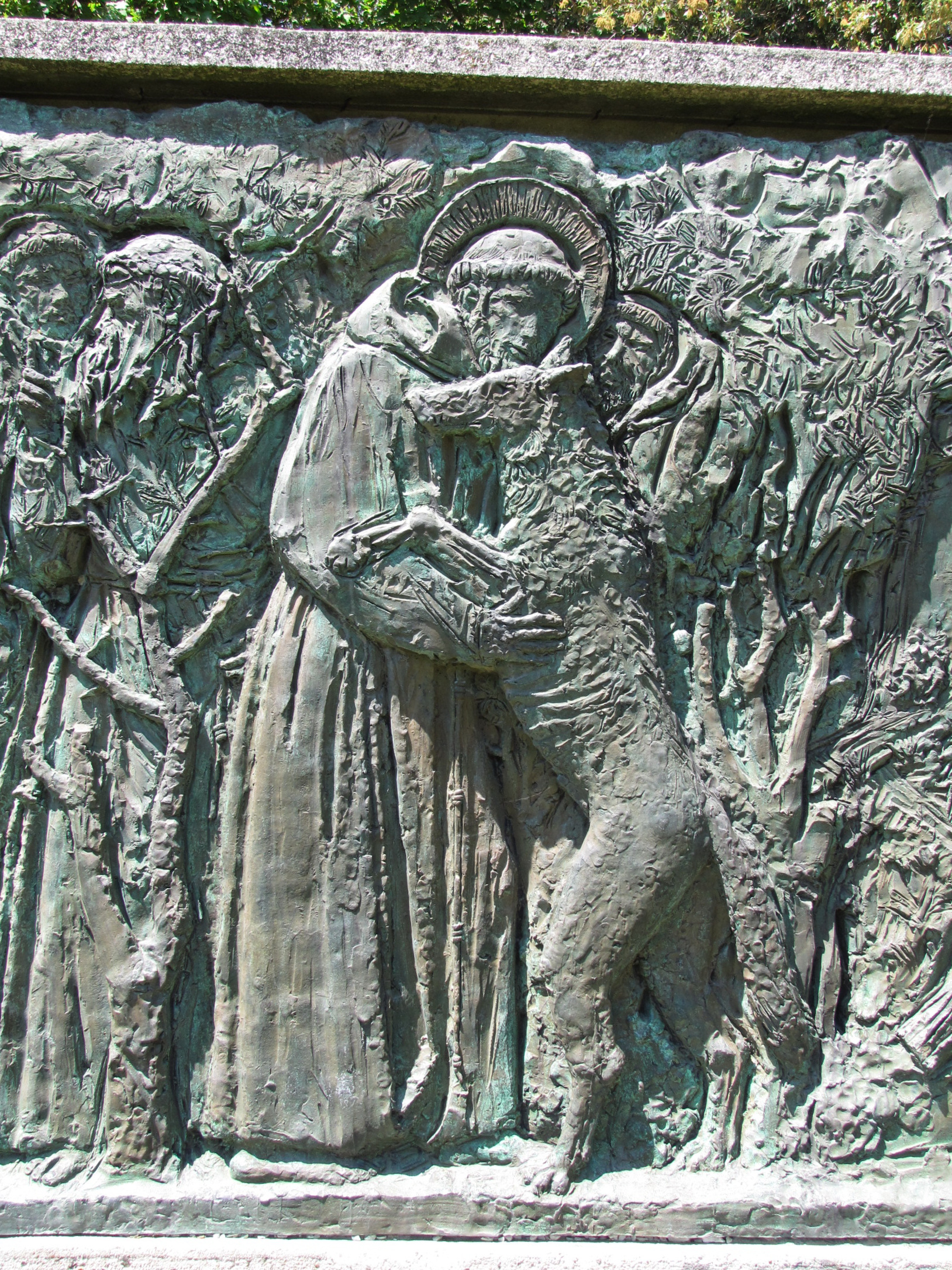 a carving depicting jesus surrounded by angels and an animal