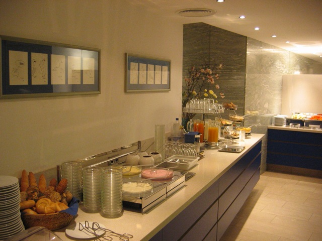 a buffet table and counter set up with plates and drinks