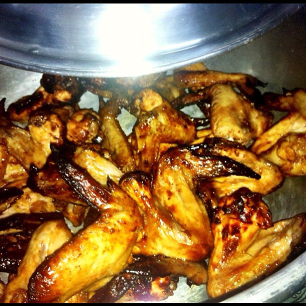 cooked chicken wings sit in a silver bowl