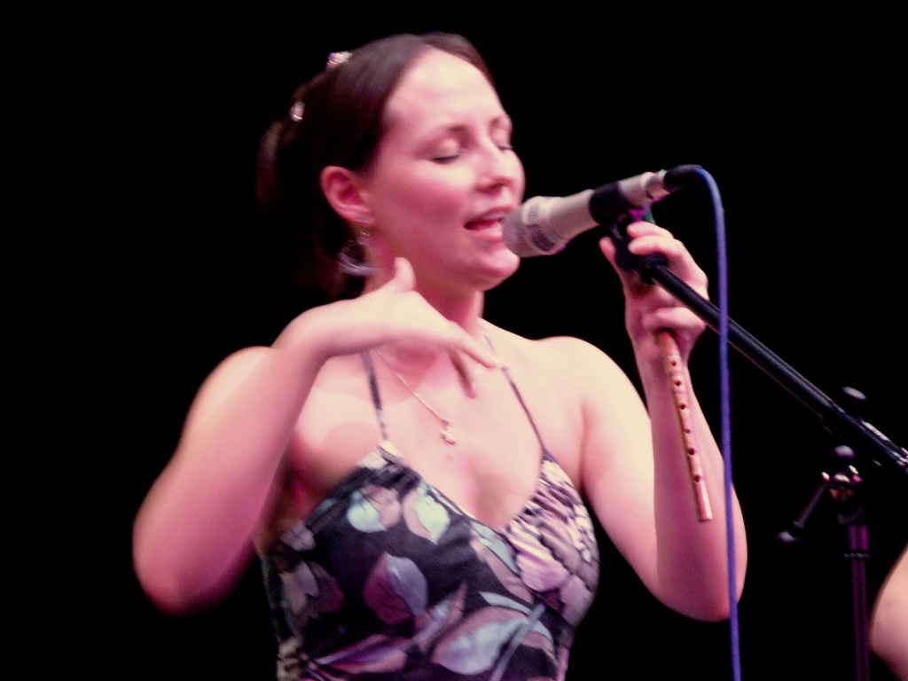 a woman holding a microphone to her left
