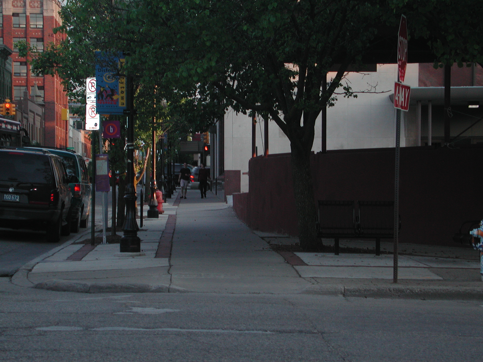 an empty street in the city with a few cars parked