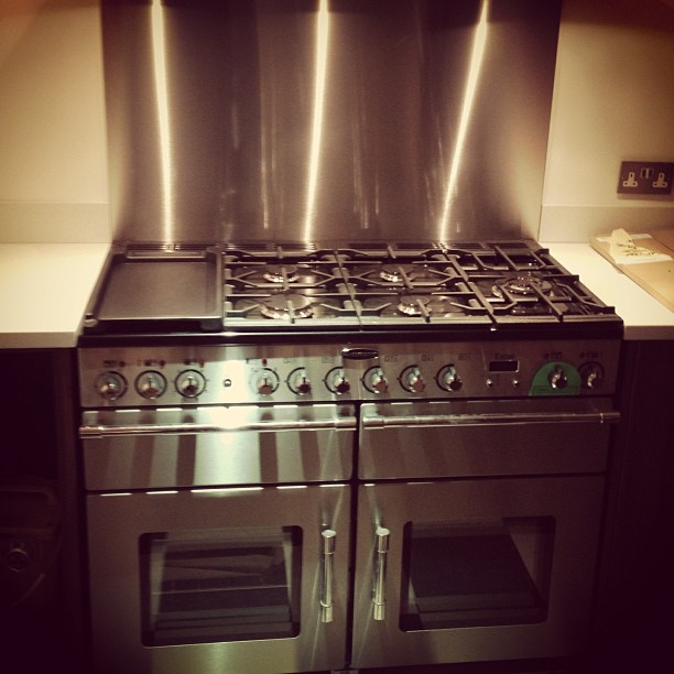 a silver stove top oven sitting inside of a kitchen