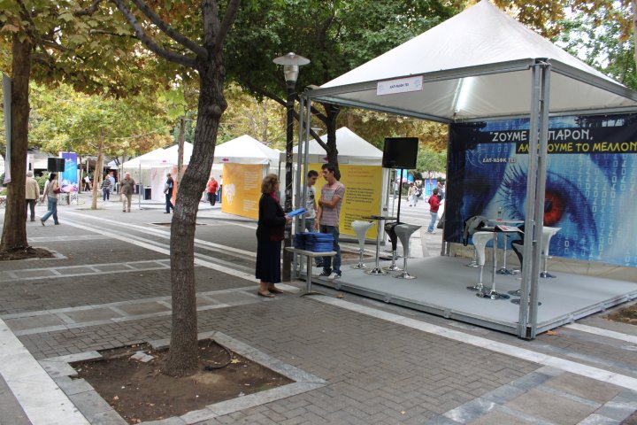 a group of people standing under a canopy near trees