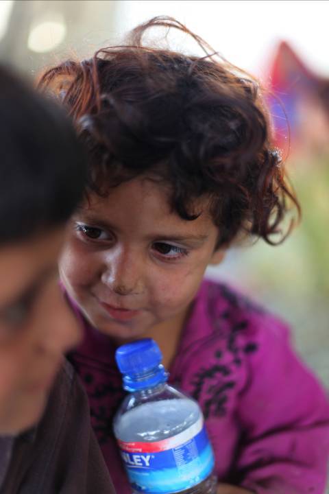 a  with her hand on her mouth holds a water bottle