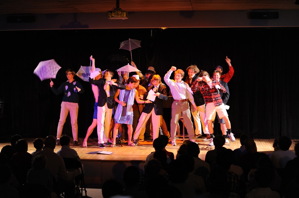 a group of people stand on stage in front of an audience