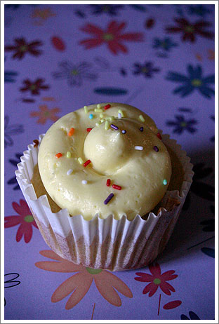 a cupcake is shown on a table covered with flowers