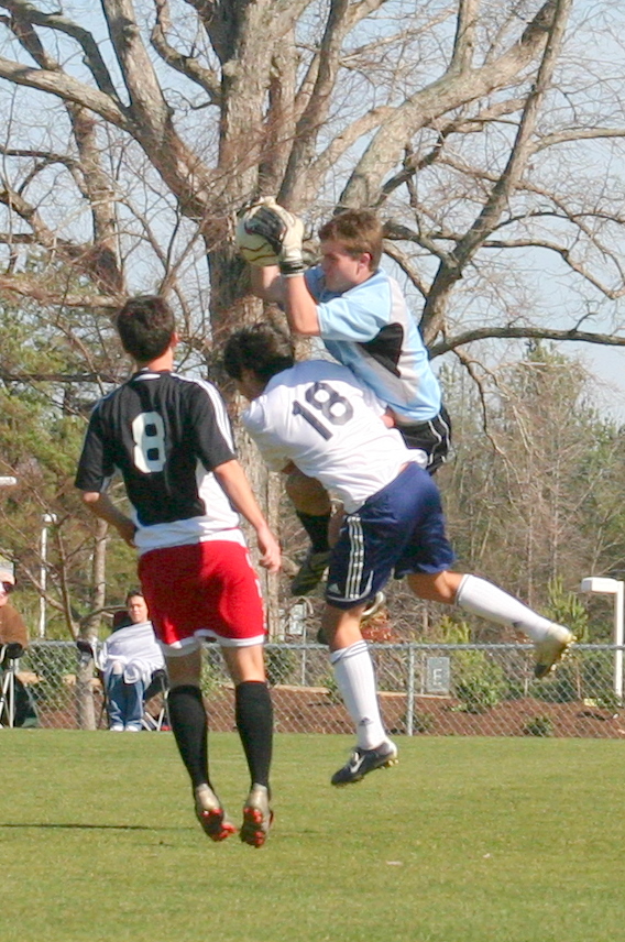 a group of soccer players playing a game of soccer