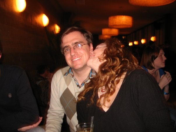 a man and woman sharing a kiss at a restaurant