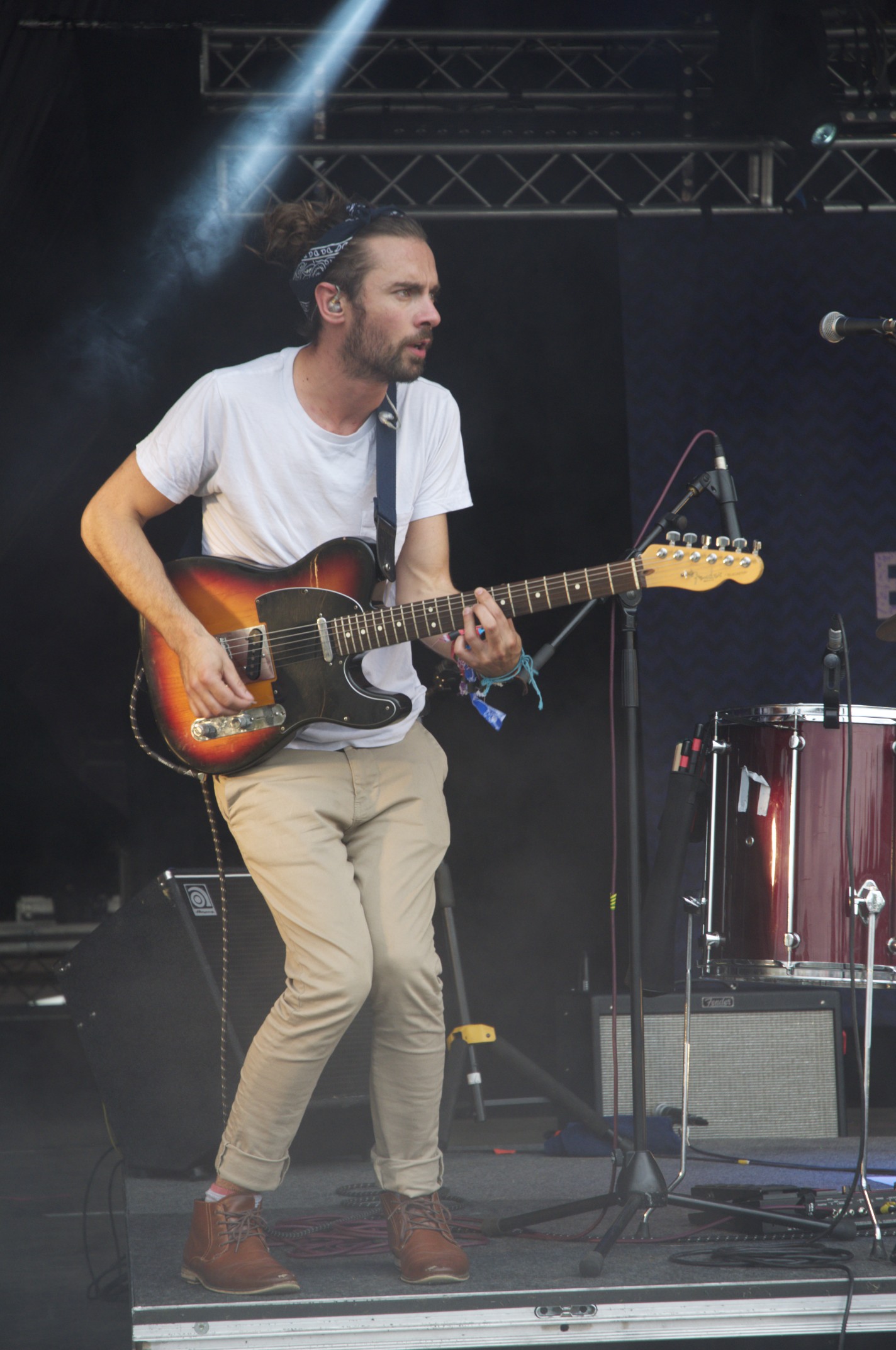 a man with a beard playing a guitar at a concert