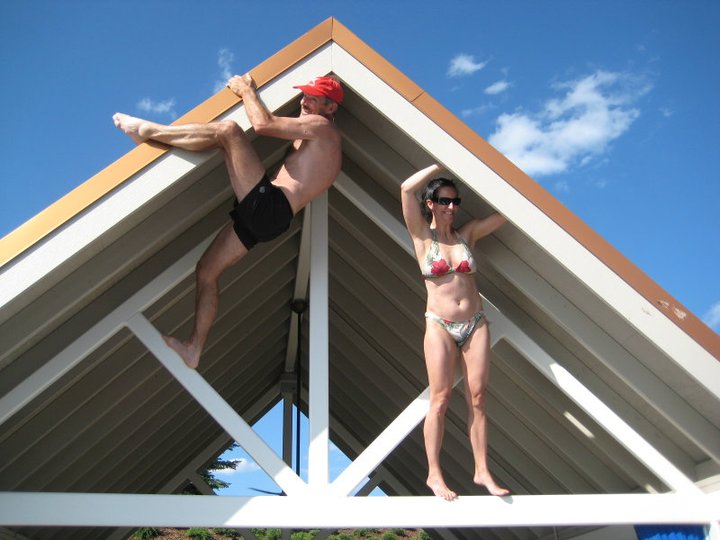 a man and woman in swimsuits are on a white roof