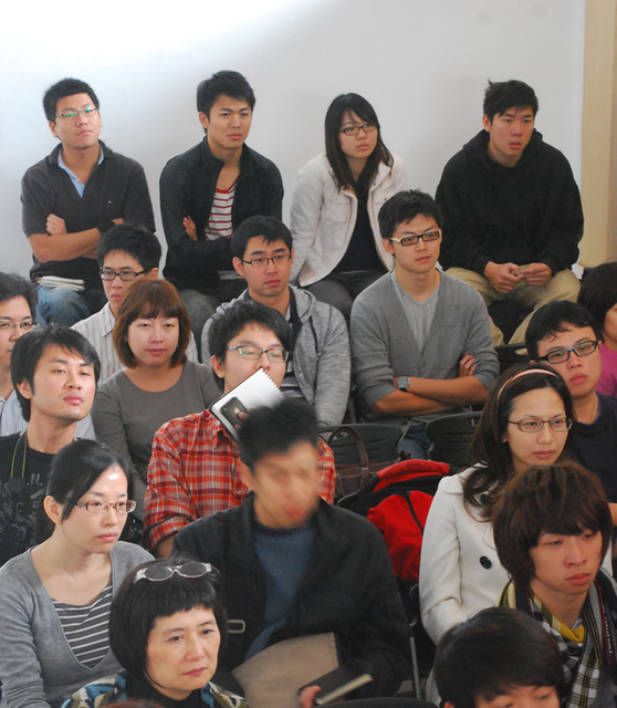 many asian people are seated in a room