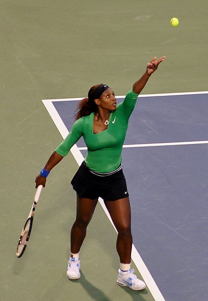 a woman tennis player holding her racket ready to hit the ball