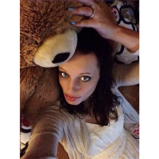 a woman in a white shirt with a stuffed animal on her head