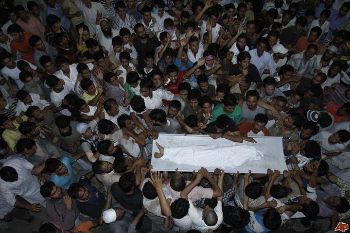 a large group of people who are standing up and looking down at a casket in the middle of a crowd