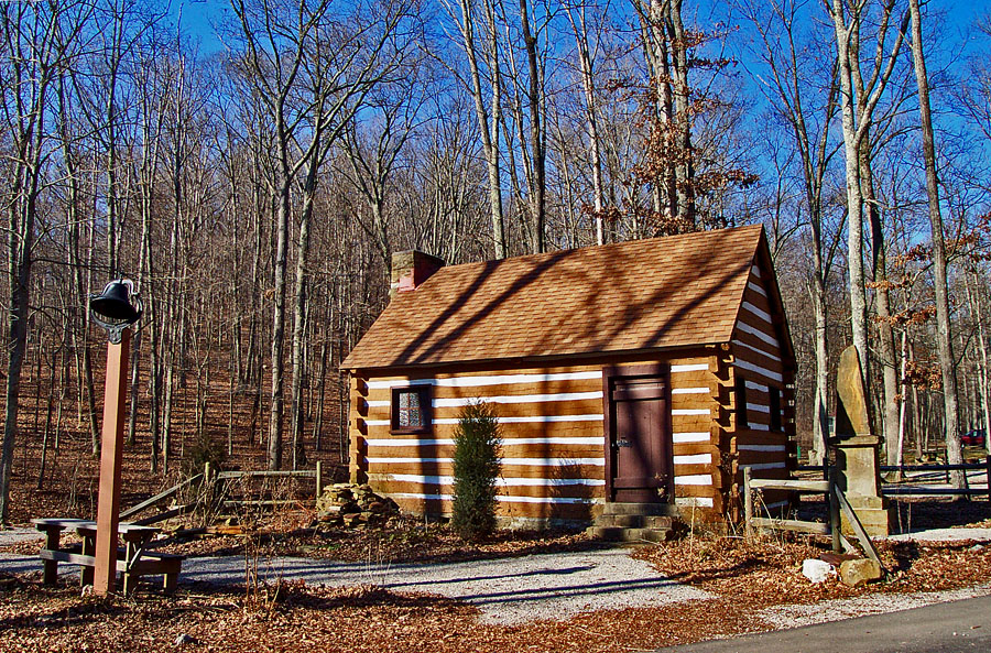 there is a log cabin next to a tree