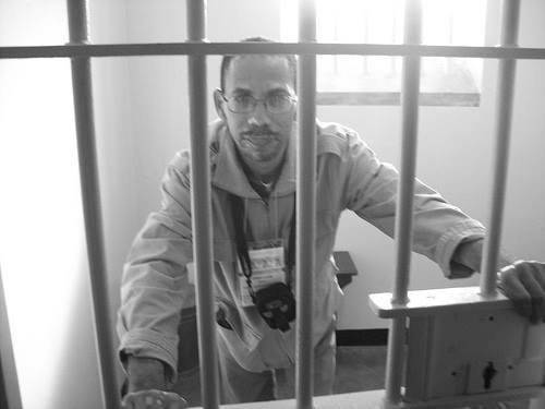 a man standing in front of a prison cell