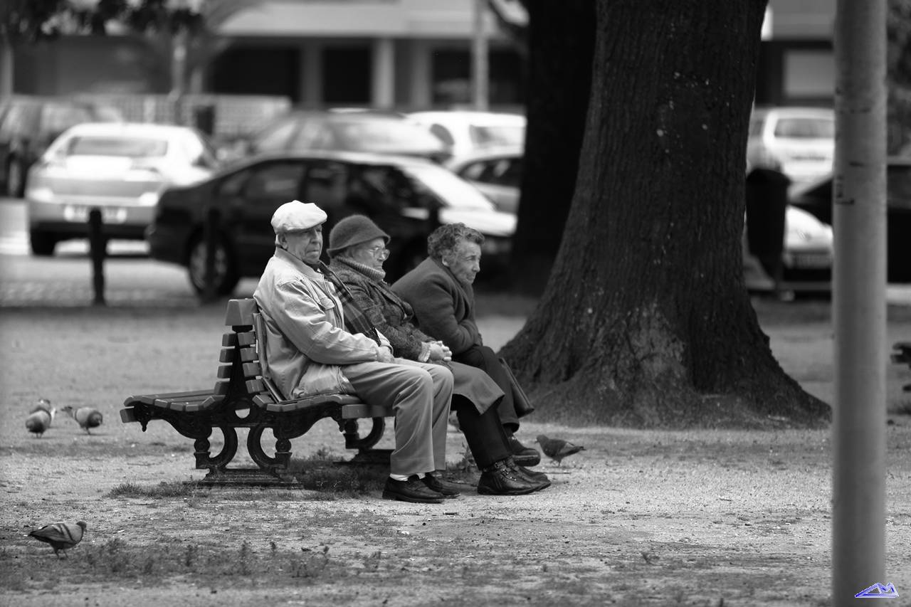 two older people are sitting on a park bench