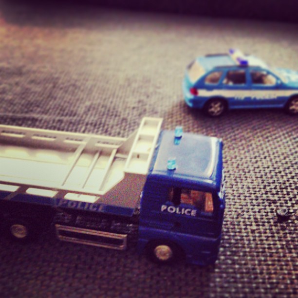 two toy trucks sitting on the ground next to each other