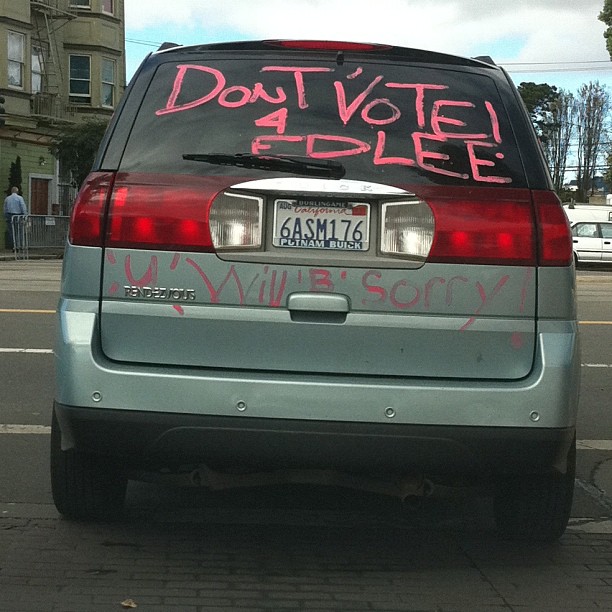 a parked car that has some pink writing on it
