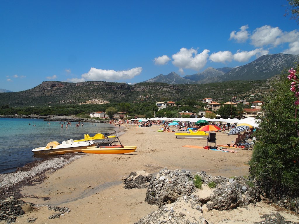 the sandy beach is clear and blue and has a row boat