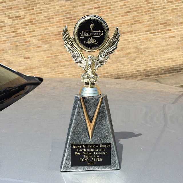 a shiny silver vehicle with an award on top