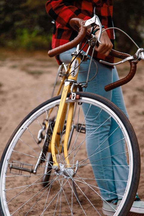 a girl walking and holding onto a bicycle