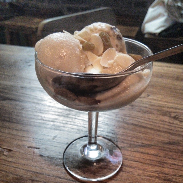two scoops of ice cream sitting in a glass bowl
