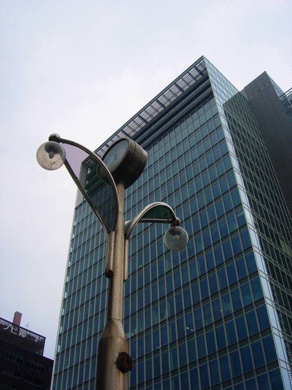 two lamp posts near the tall building