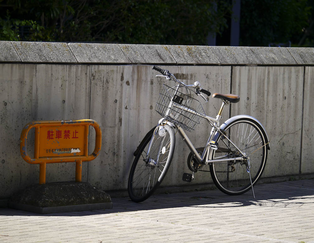 a silver bicycle is locked to a wall