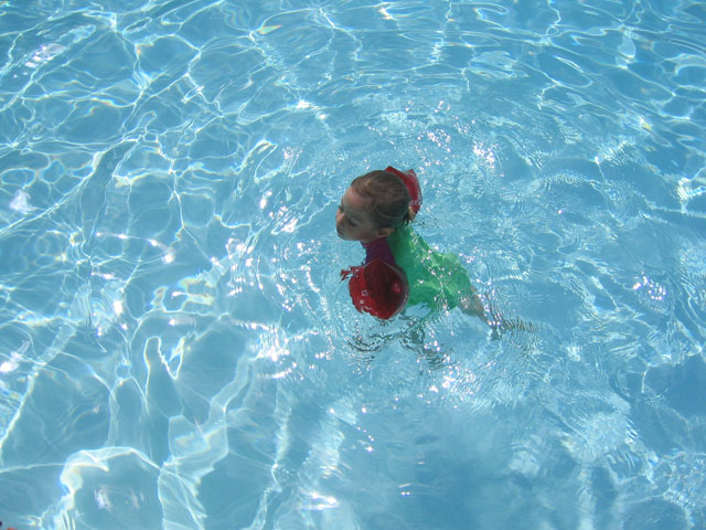 a  wearing a green bikini floating in the water