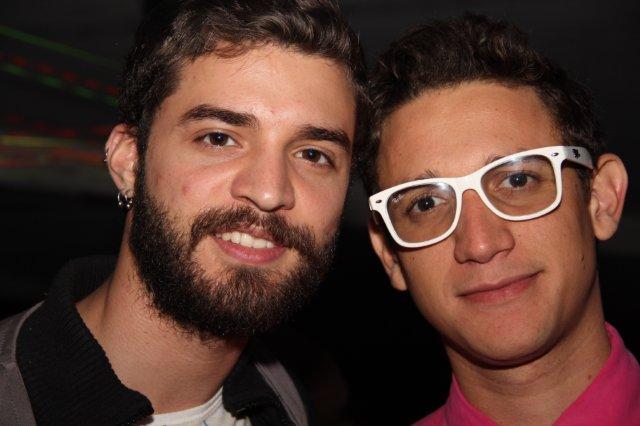 two young men posing for the camera and wearing glasses