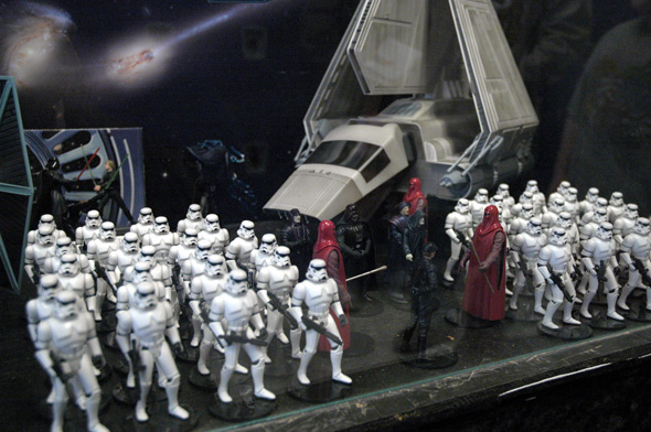 a bunch of toy people are gathered in front of a star wars scene