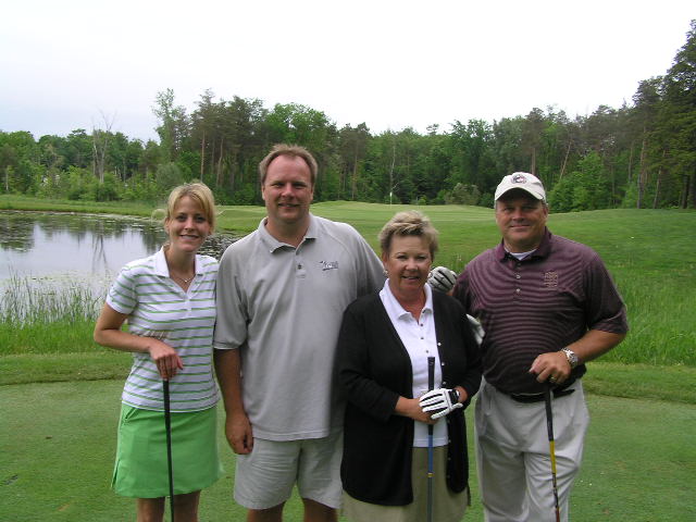 the group of people are taking a break together on the golf course