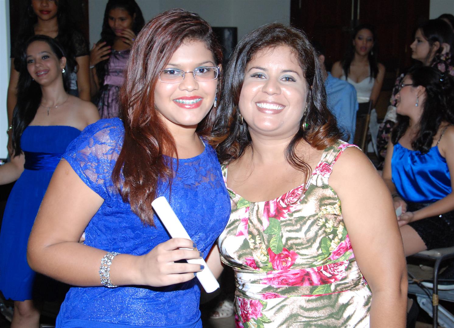 two girls standing next to each other holding a remote control