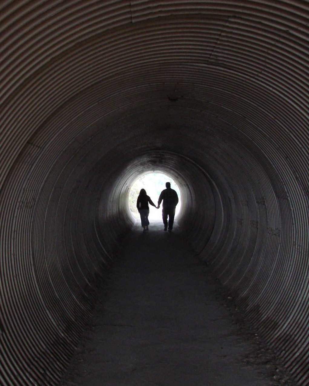 a couple is walking down the tunnel together