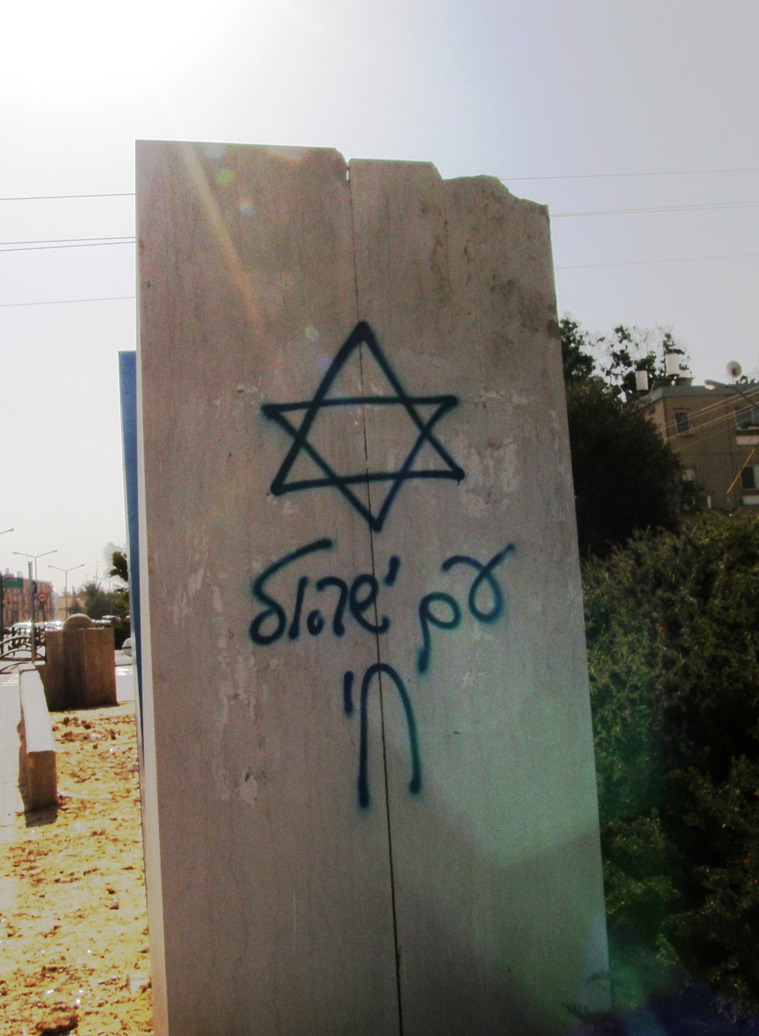 graffiti on the side of a building and sign that says israel