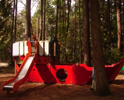 the children slide is in a forest that is red and green