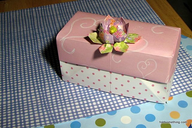 a pink floral shaped gift box on a table