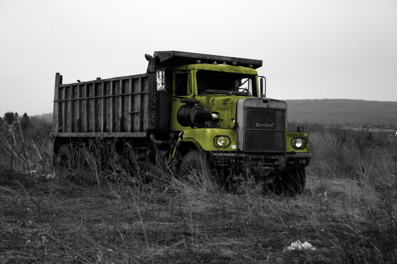 an old dump truck sitting in a field