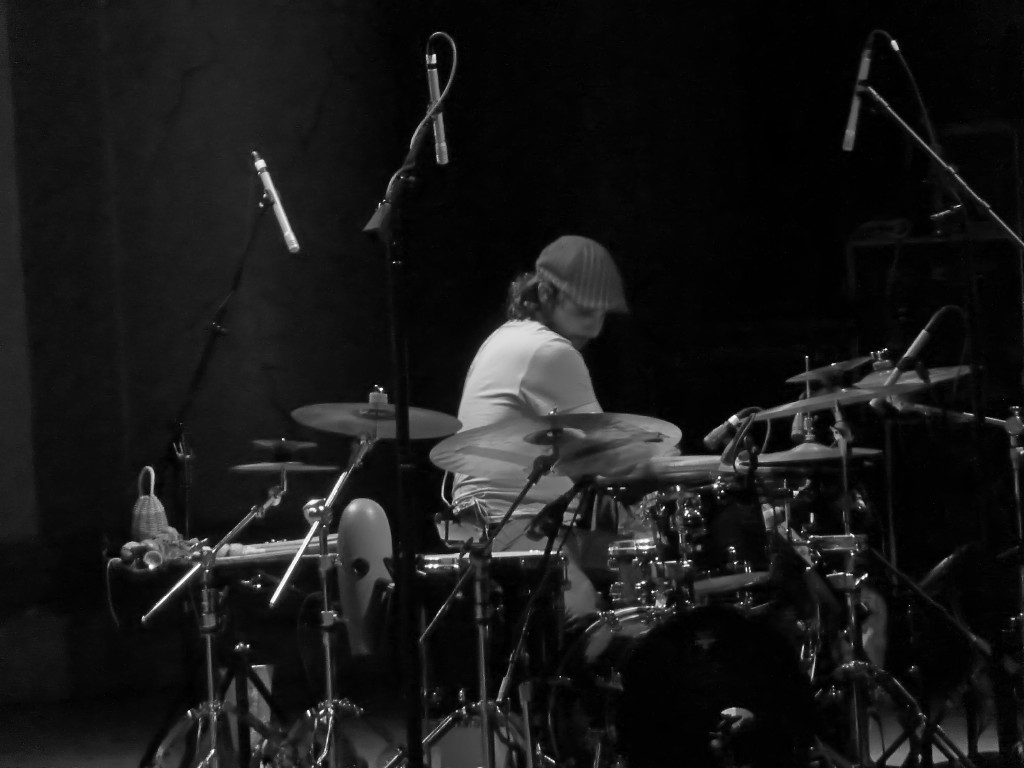 a man playing drums at the front of a set of drums