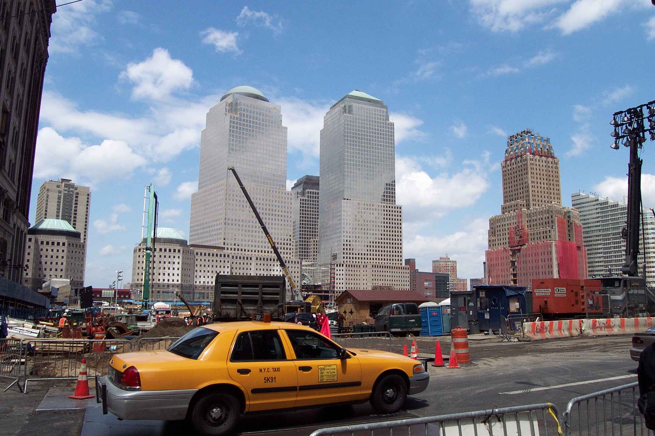 there is a yellow taxi on the street with construction in the back