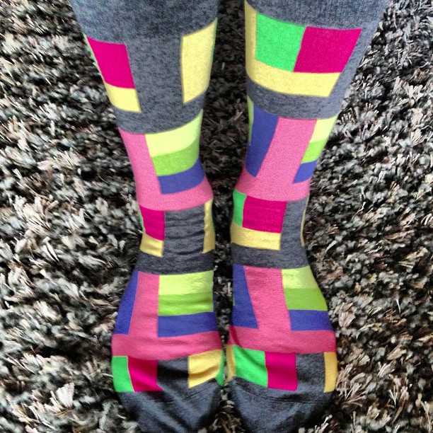 a person standing with their feet up wearing colorful socks