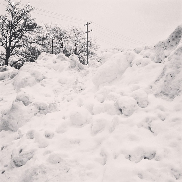 black and white pograph of snow piled up against rock
