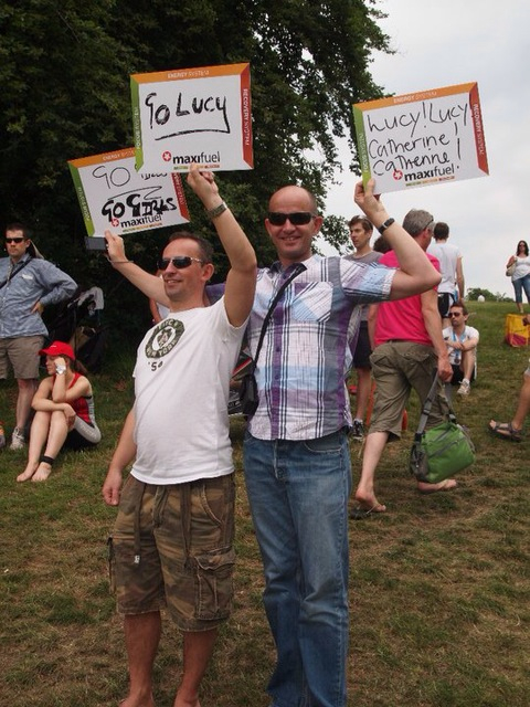 a couple of men standing on top of a field holding up signs