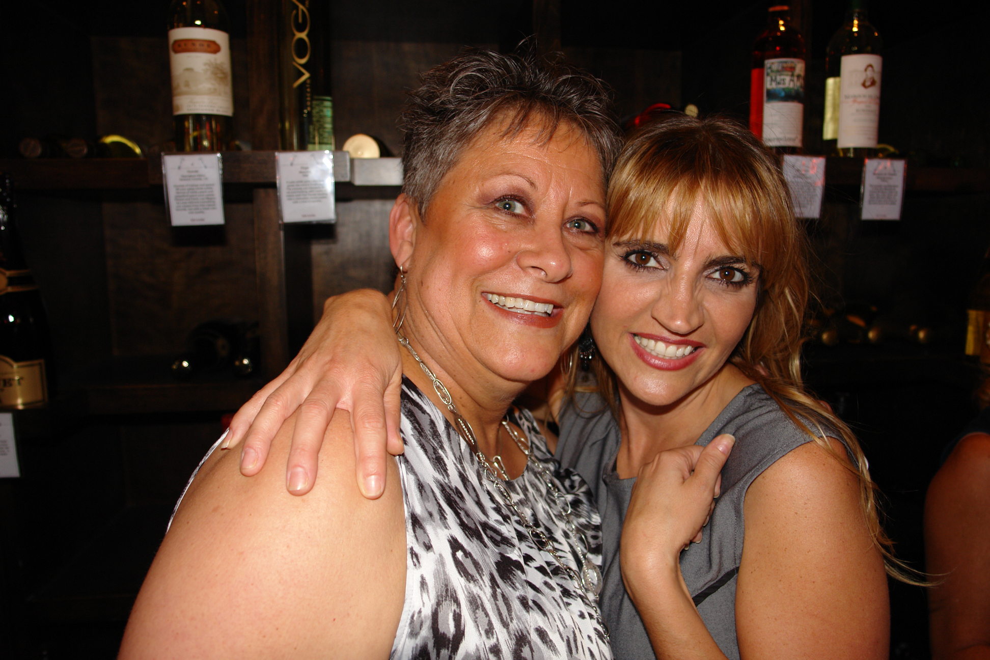 a lady hugging her mother as she poses for a picture