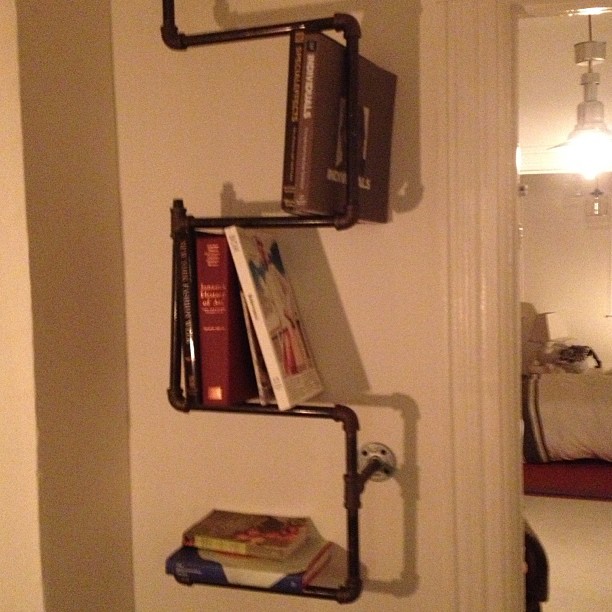 a wall filled with three metal shelfs mounted on top of each other