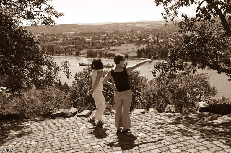 a couple standing on a stone walkway near a river