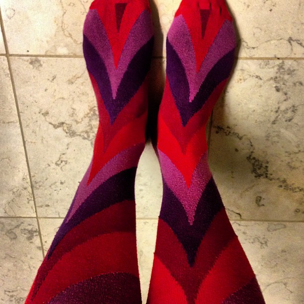 a person wearing colorful socks with purple and red chevroned design